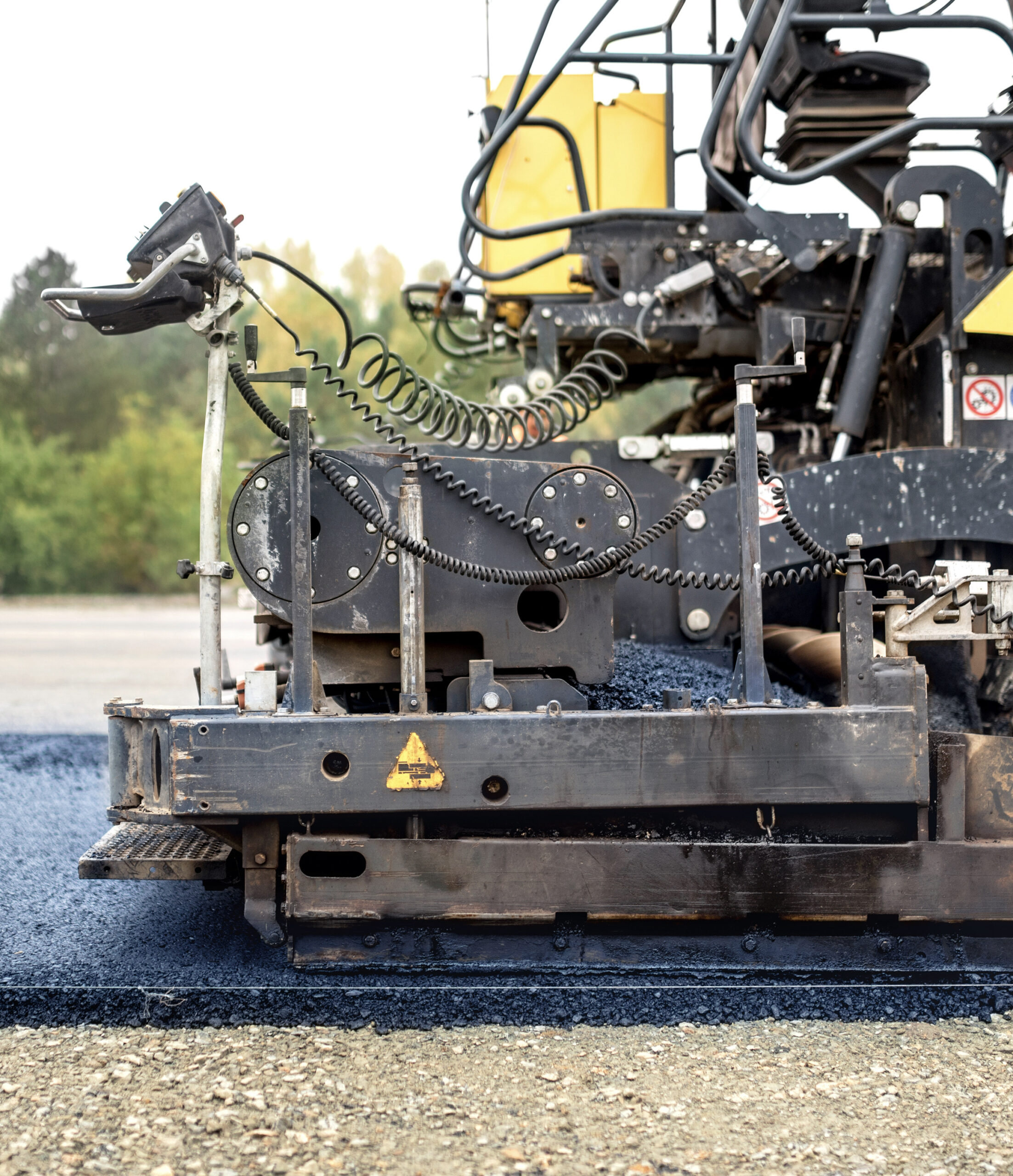 industrial pavement truck laying fresh asphalt on construction site, asphalting